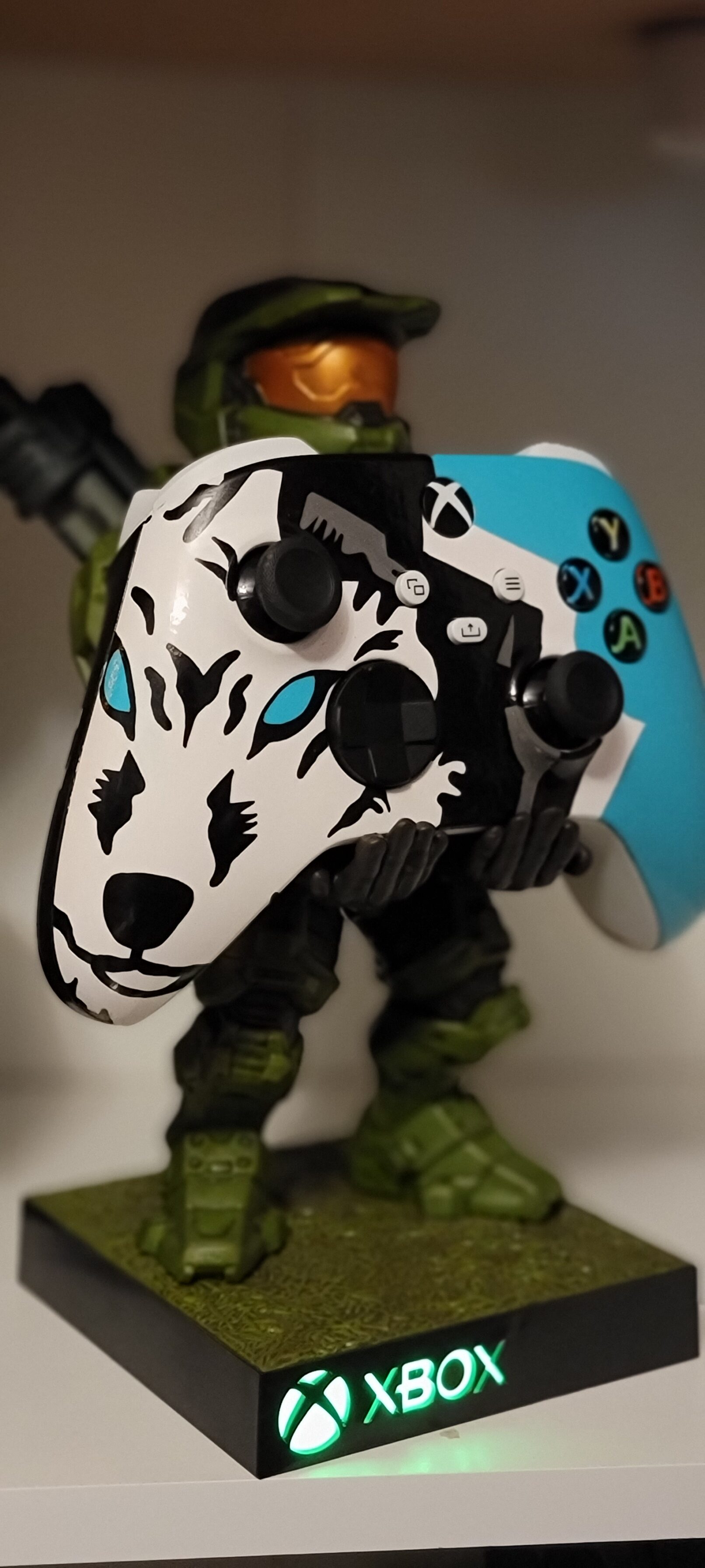 a figurine of Master Chief holding a painted xbox controller