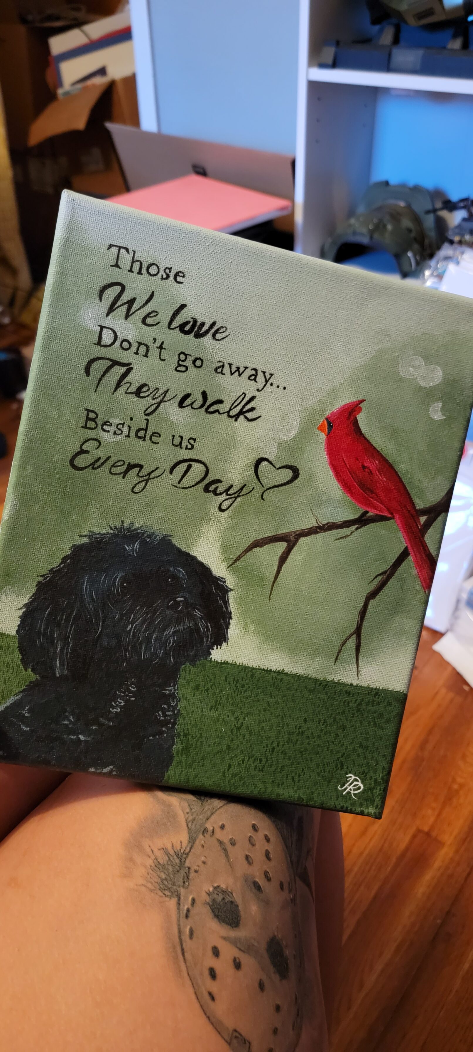 a painting of a black poodle and a cardinal on a green background