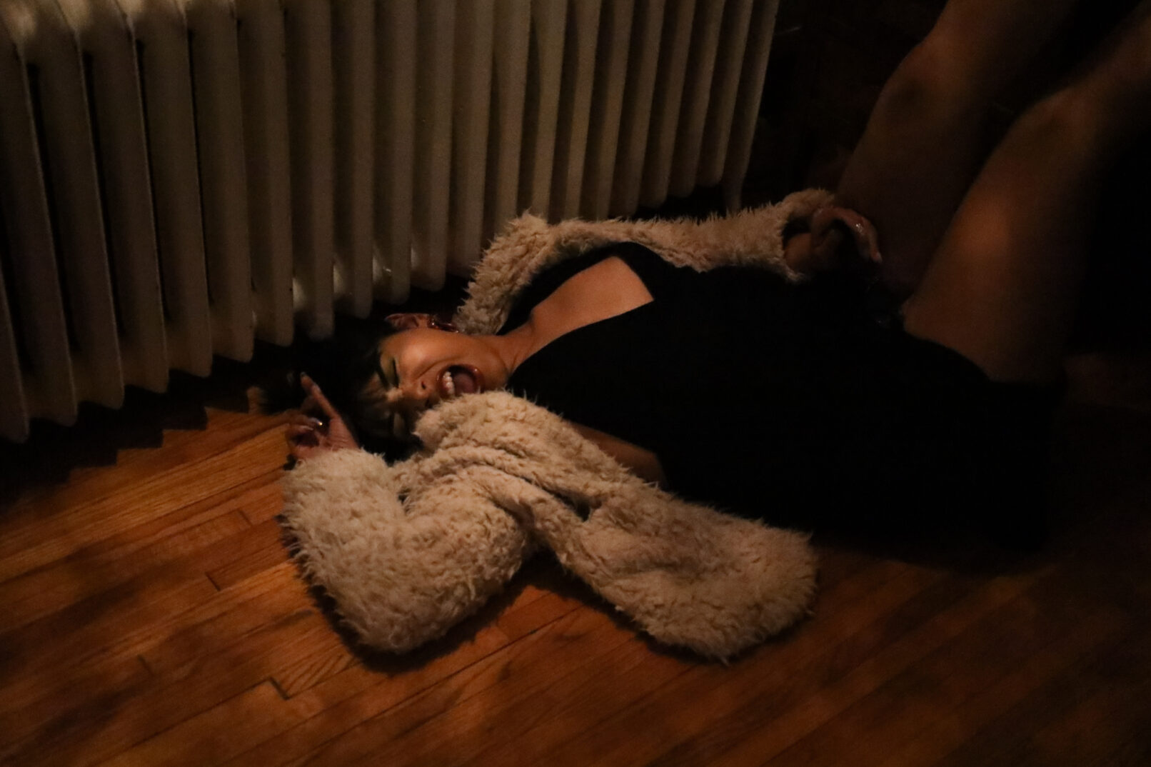 a woman with sunglasses laying on the floor, screaming