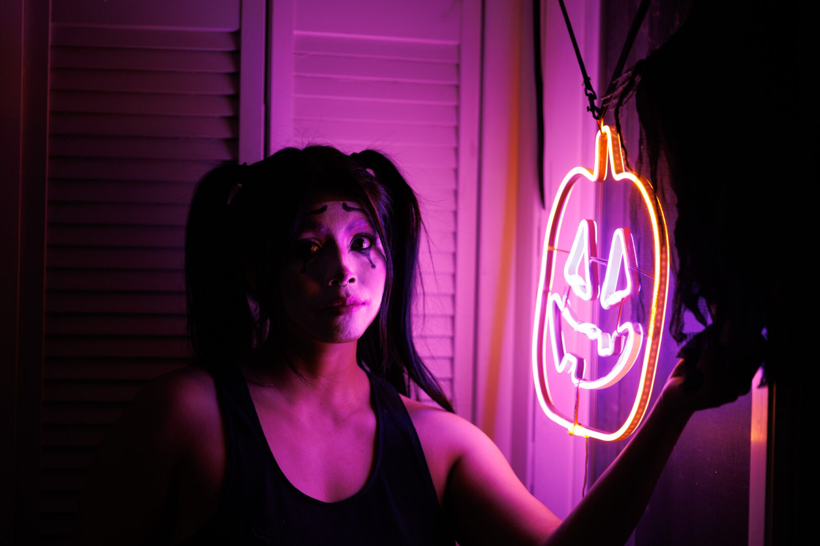 a woman in the dark with purple and orange light coming off of the window