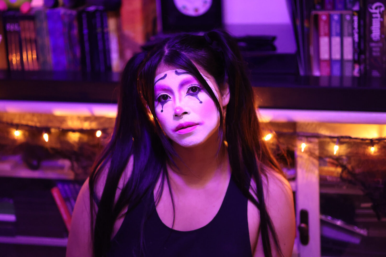 a woman with clown makeup and pigtails sitting on the floor